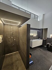 Modernes Badezimmer, ausgestattet mit einer Dusche und einem Waschbecken, in einem klaren und minimalistischen Design.