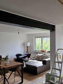 Modernes Wohnzimmer, ausgestattet mit einem bequemen Sofa und einem eleganten Tisch, schafft eine einladende Atmosphäre.